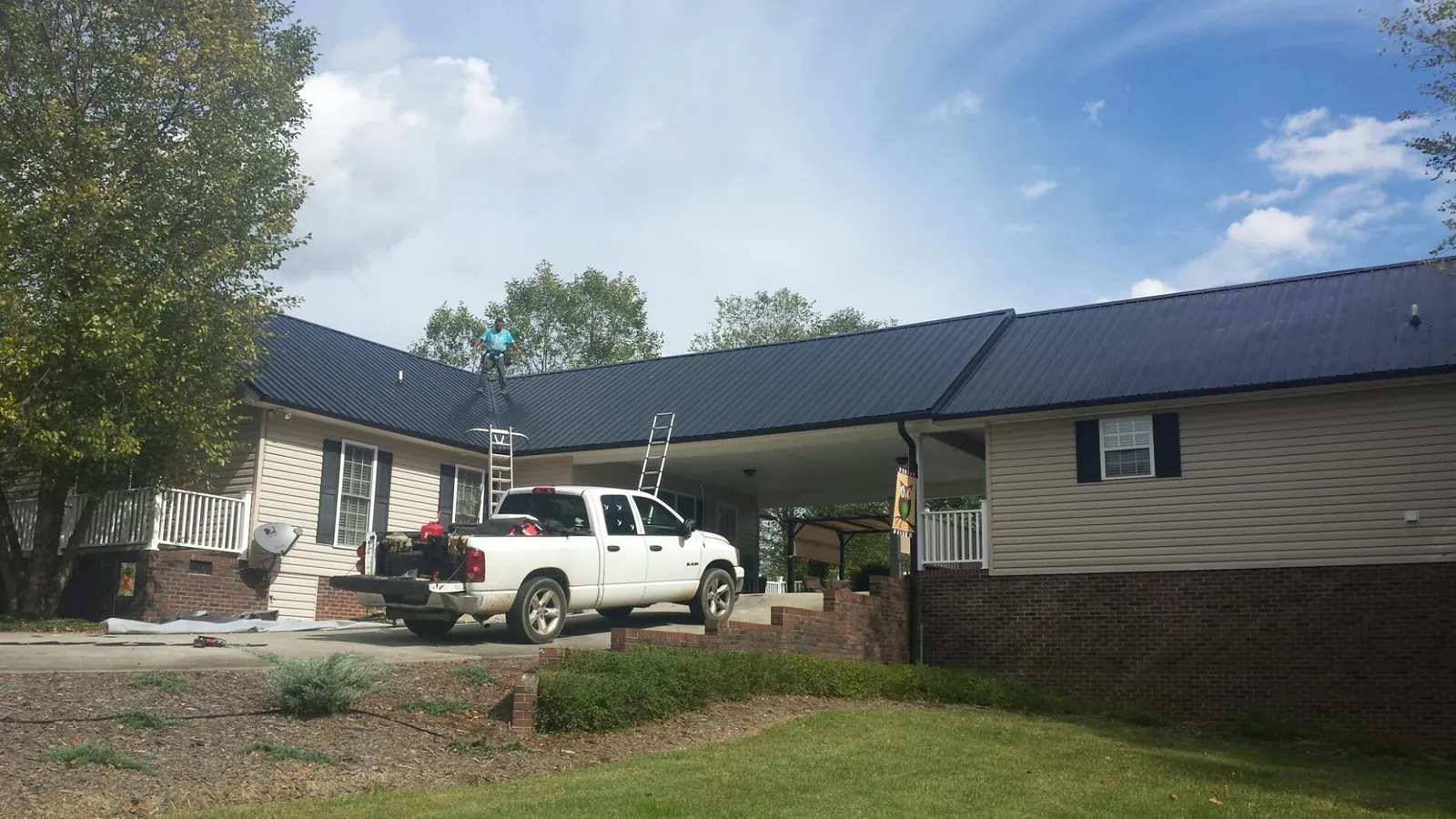 Black metal roof over a home and attached breezeway with ladders set in Pacific